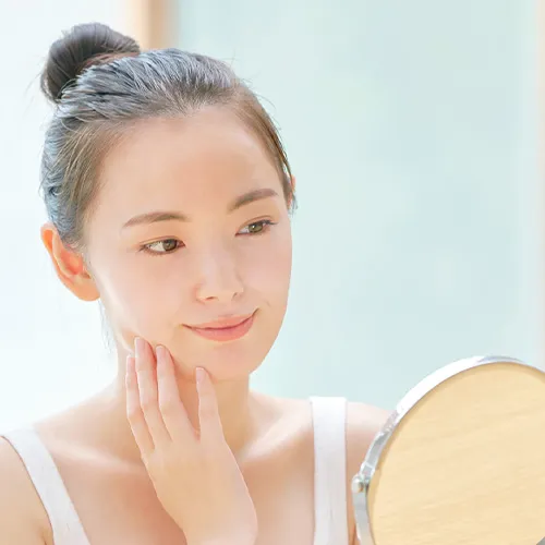 糸リフトの効果を確認するように鏡を見る女性
