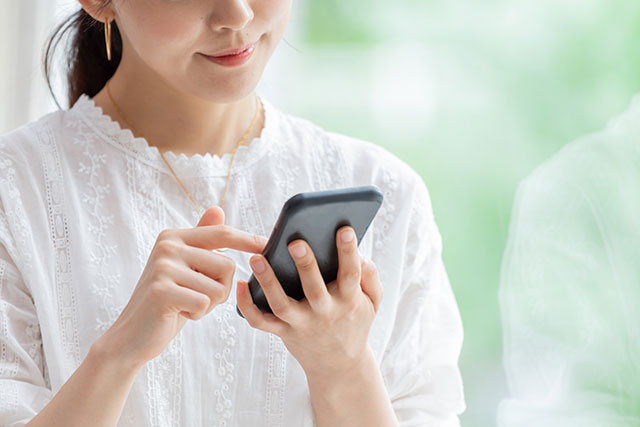 携帯で予約する女性