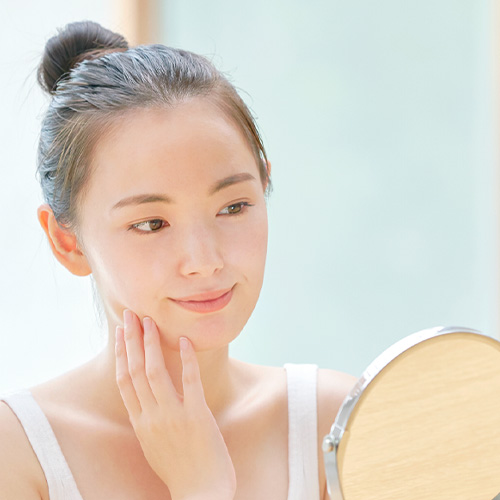 糸リフトの効果を確認するように鏡を見る女性